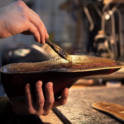 Shoemaker applying glue for leather materials.